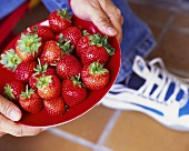 Man holding plate of strawberries