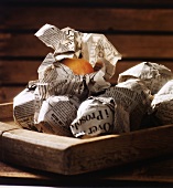 Several apples wrapped in newspaper
