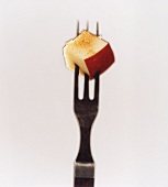 A piece of apple with cinnamon and sugar on a fork