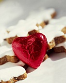 A red chocolate heart in front of cinnamon stars