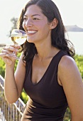Junge Frau mit Weißwein auf der Terrasse
