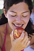 Young woman eating nectarine