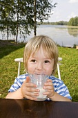 Kleiner Junge trinkt ein Glas Milch