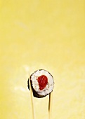 Maki-sushi with tuna on chopsticks