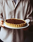 Person serving chocolate tart