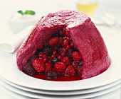 Summer pudding with berries (turned-out, a piece cut)
