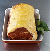 Raw rolled beef joint in roasting dish