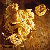 Ribbon pasta on wooden background