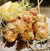 Skewered meat with tomatoes, rosemary and lemon