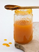 Apricot jam in jar with wooden spoon