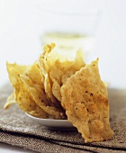 Pieces of flatbread in front of glass of white wine