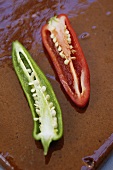 Two chili pepper halves (red and green)