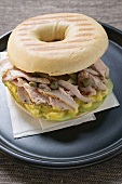 Bagel mit Schweinefilet, Kapern und Senfrelish auf Teller