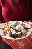 Hands holding a plate of Christmas biscuits