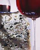 Piece of Roquefort between glasses of red wine