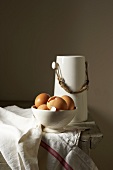 Eggs in white bowl, jug of milk