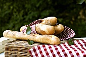 Baguettes in checked napkin on basket out of doors