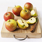 Äpfel mit Messer auf einem Holzbrett