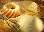 Still life with flour, cereal ears and gugelhupf