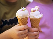Children’s hands holding ice cream cones
