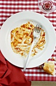 Plate with scraps of spaghetti bolognese