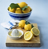 Zitronen und Zitruspresse mit Zitronensaft