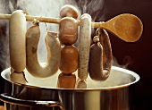 Various types of sausage on kitchen spoon