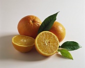 Orange halves and whole oranges with leaves