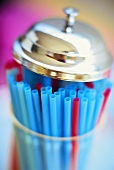 Coloured straws in container