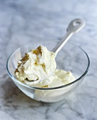 Mascarpone with spoon in a glass bowl