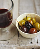Eingelegte Oliven mit einem Glas Wein