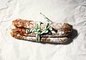 Three salami tied together on paper