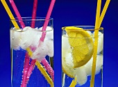 Two glasses of cold mineral water with coloured straws