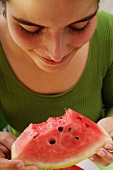 Frau isst ein Stück Wassermelone