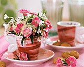Small arrangement of carnations and lobelia in coffee cup