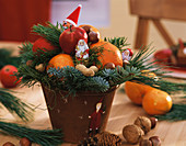 Arrangement with Father Christmases, mandarins, apples & nuts