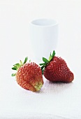 Two strawberries and a small bowl