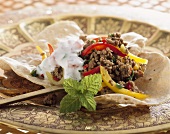 Ground beef with peppers and raita on chapatti (India)