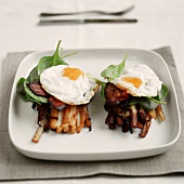 Fried egg with bacon and spinach on potato sticks