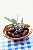 Black olives with twig in a small bowl