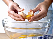 Breaking eggs into a bowl