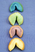 Different-coloured fortune cookies in a row