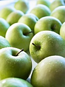 Green apples with drops of water, full frame
