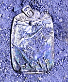 Crushed drink box on coarse blue sand