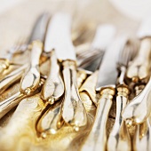 Elegant knives and forks on gold fabric