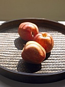 Three apples on a tray