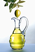 Olivenöl tropft von Olive in Karaffe
