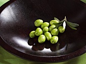 Frische grüne Oliven in einer Holzschale