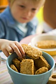 Boy reaching for wheat biscuits