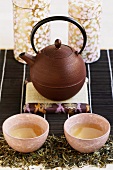 Cast-iron teapot with two tea bowls and tea caddies